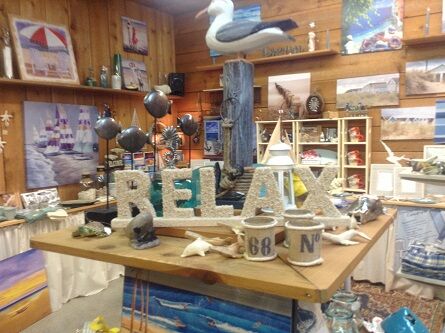 Display of items on a wooden table including a small 3D-sign 'RELAX' sitting prominently on a desk